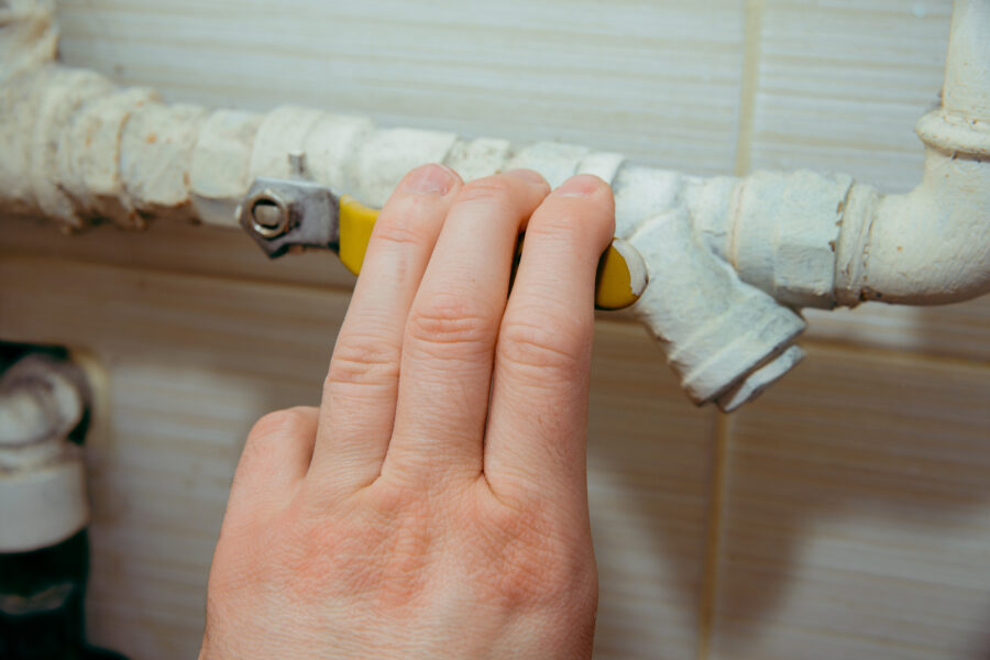 Hand adjusting valve on a yellow and white pipe