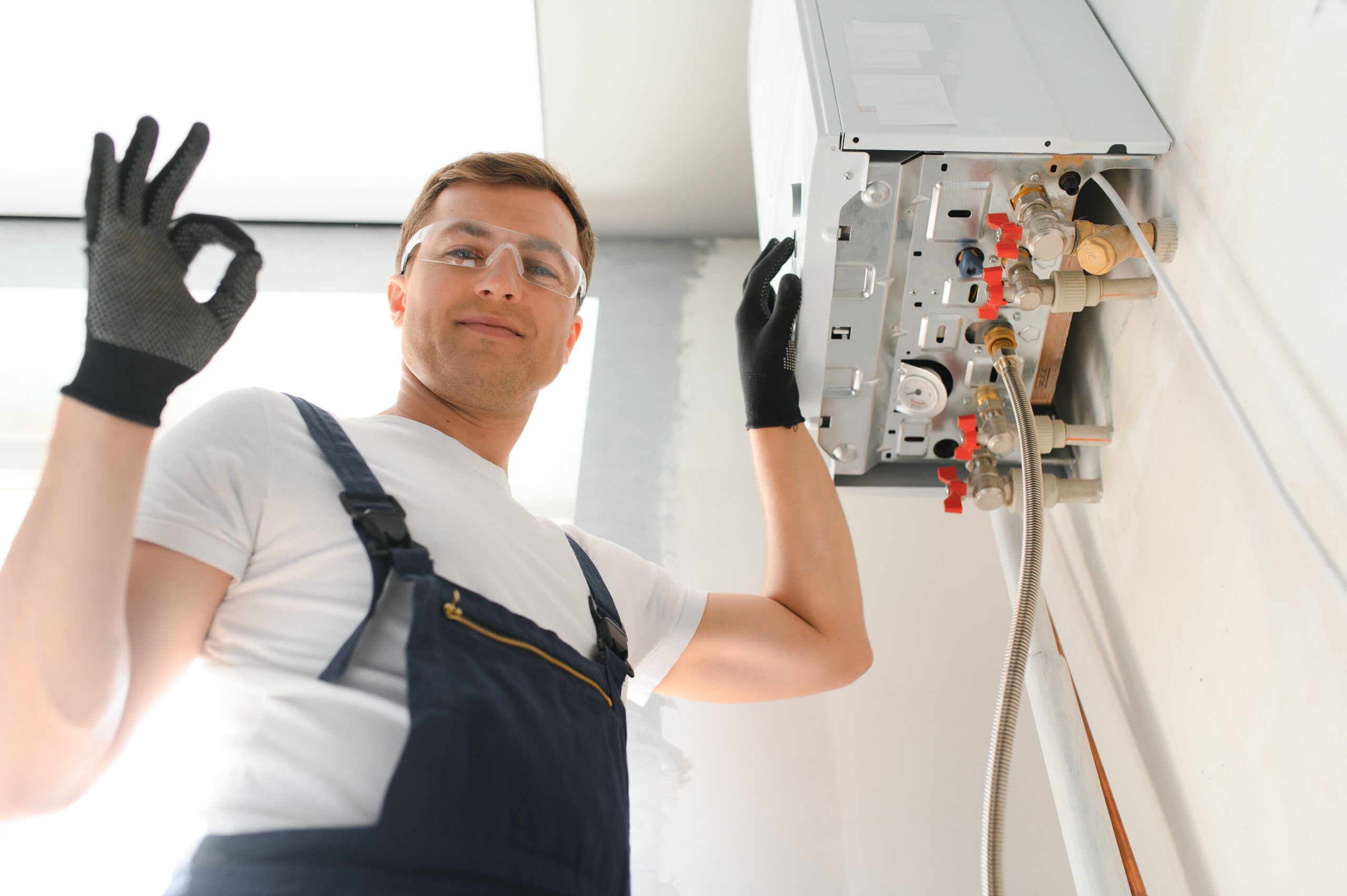 Technician repairing a wall-mounted boiler unit
