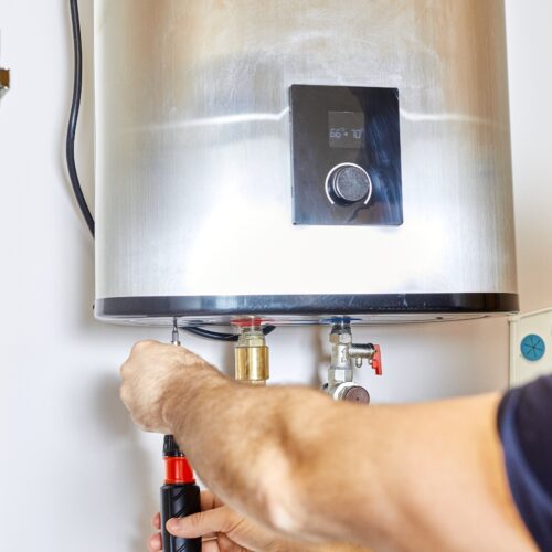 Technician adjusting water heater settings