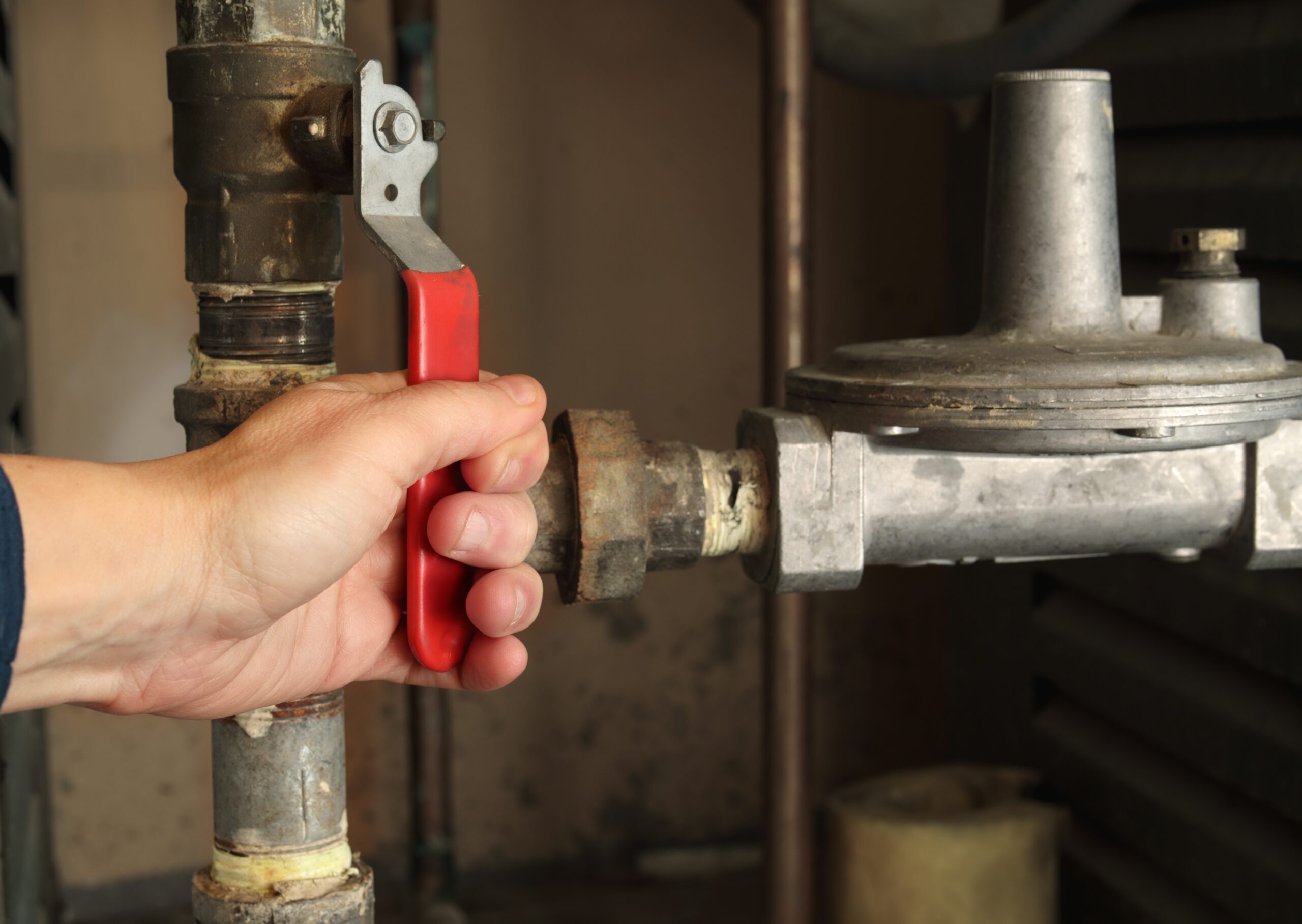 Hand using pliers to tighten pipe in industrial setting